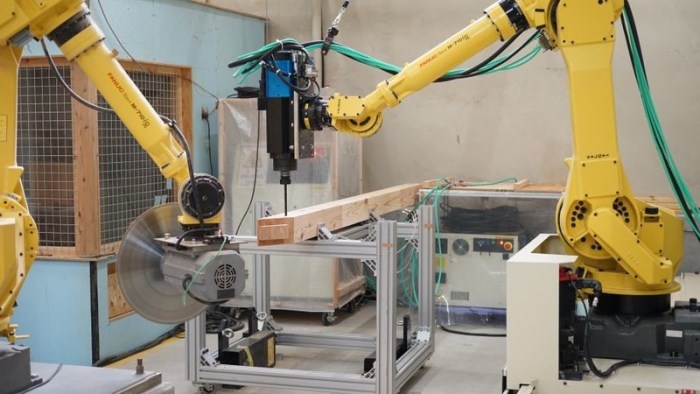 　構造材の自動加工をする2台のロボット　Ⓒ前田建設工業