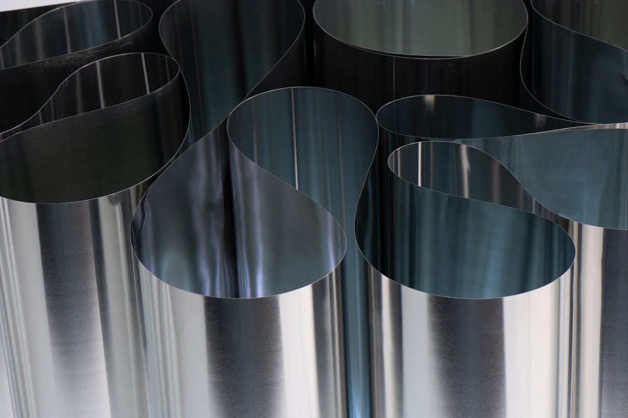 写真02:完成したテーブルの脚を上からみたところ。ひだをつくり曲面にすることにより
 合剛性が生まれると同時に、ブリキ板に金属光沢も生まれる。